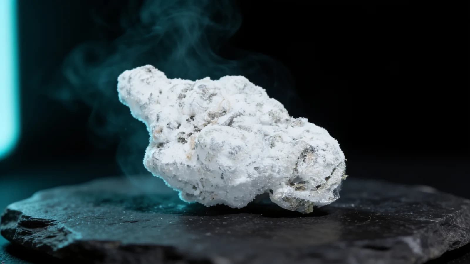 Snowball weed — cannabis bud coated in white THCa isolate powder on dark slate