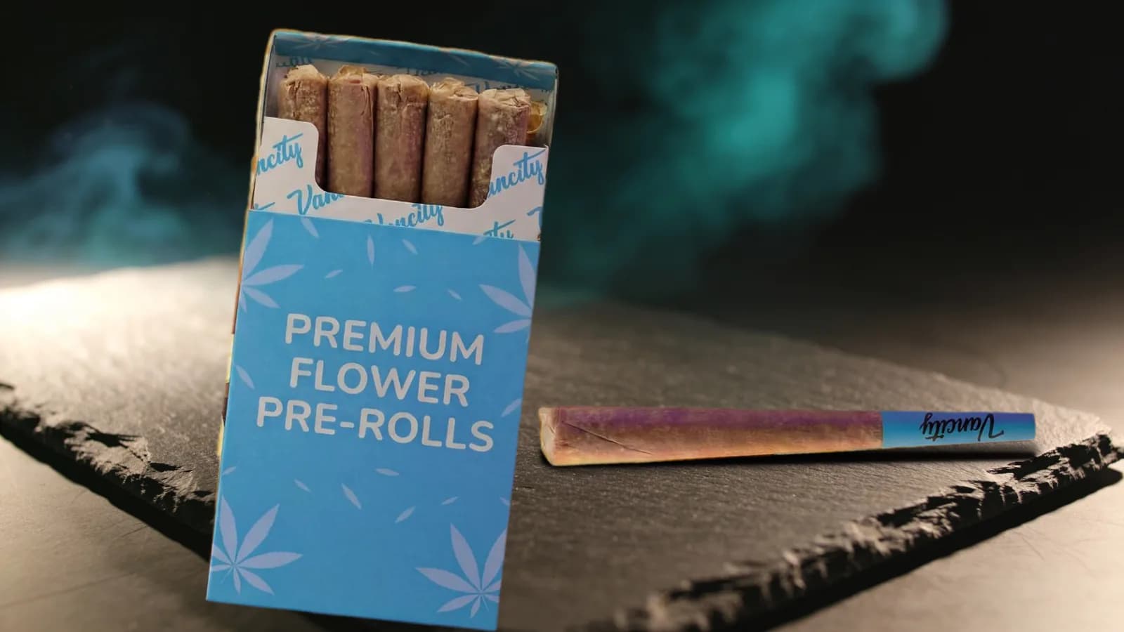 Blunt vs joint vs spliff: an open pack of pre-rolled joints with one joint lying beside it on dark slate
