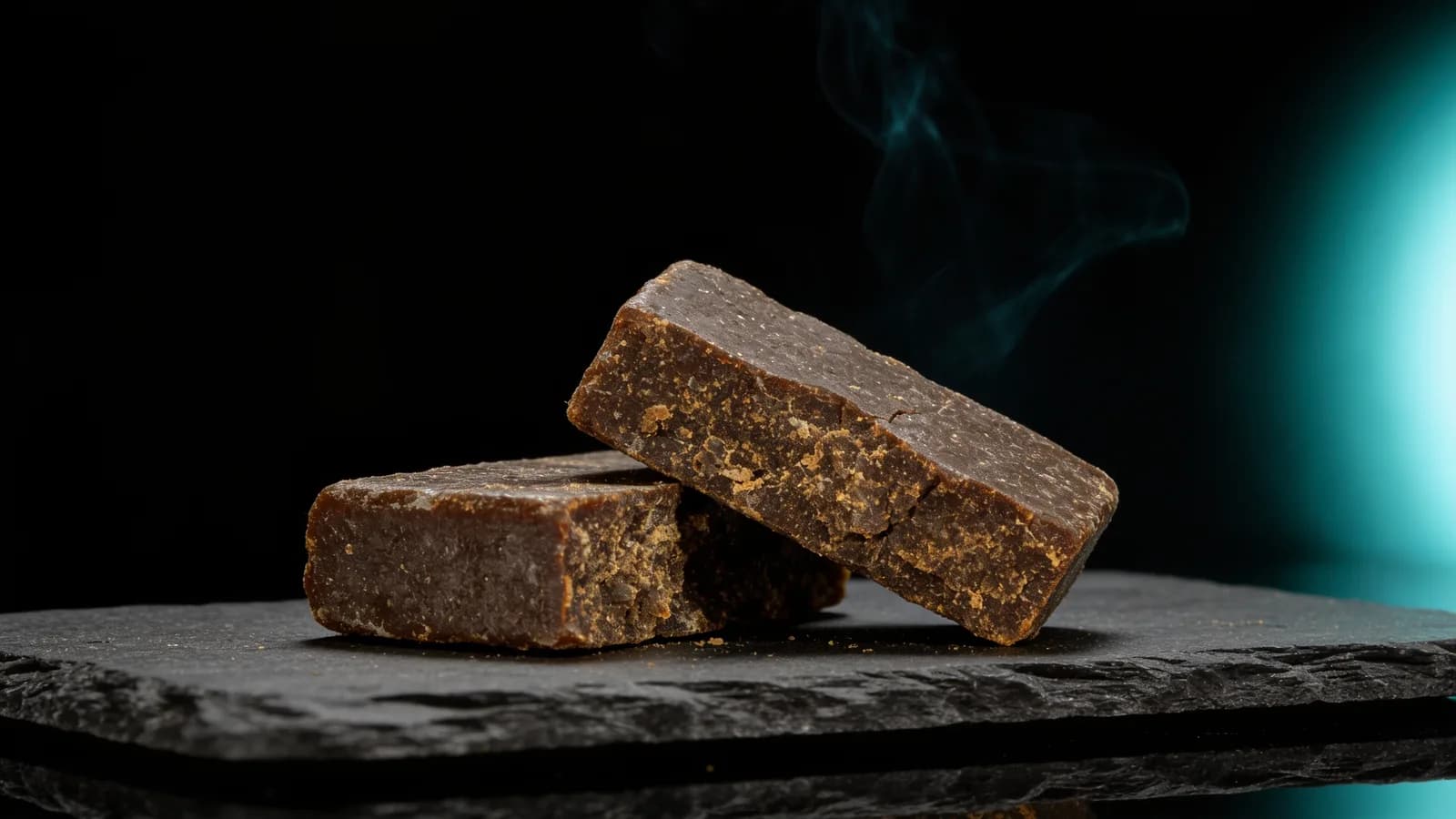 Pressed Afghan-style hash — dark brick broken open showing soft brown interior