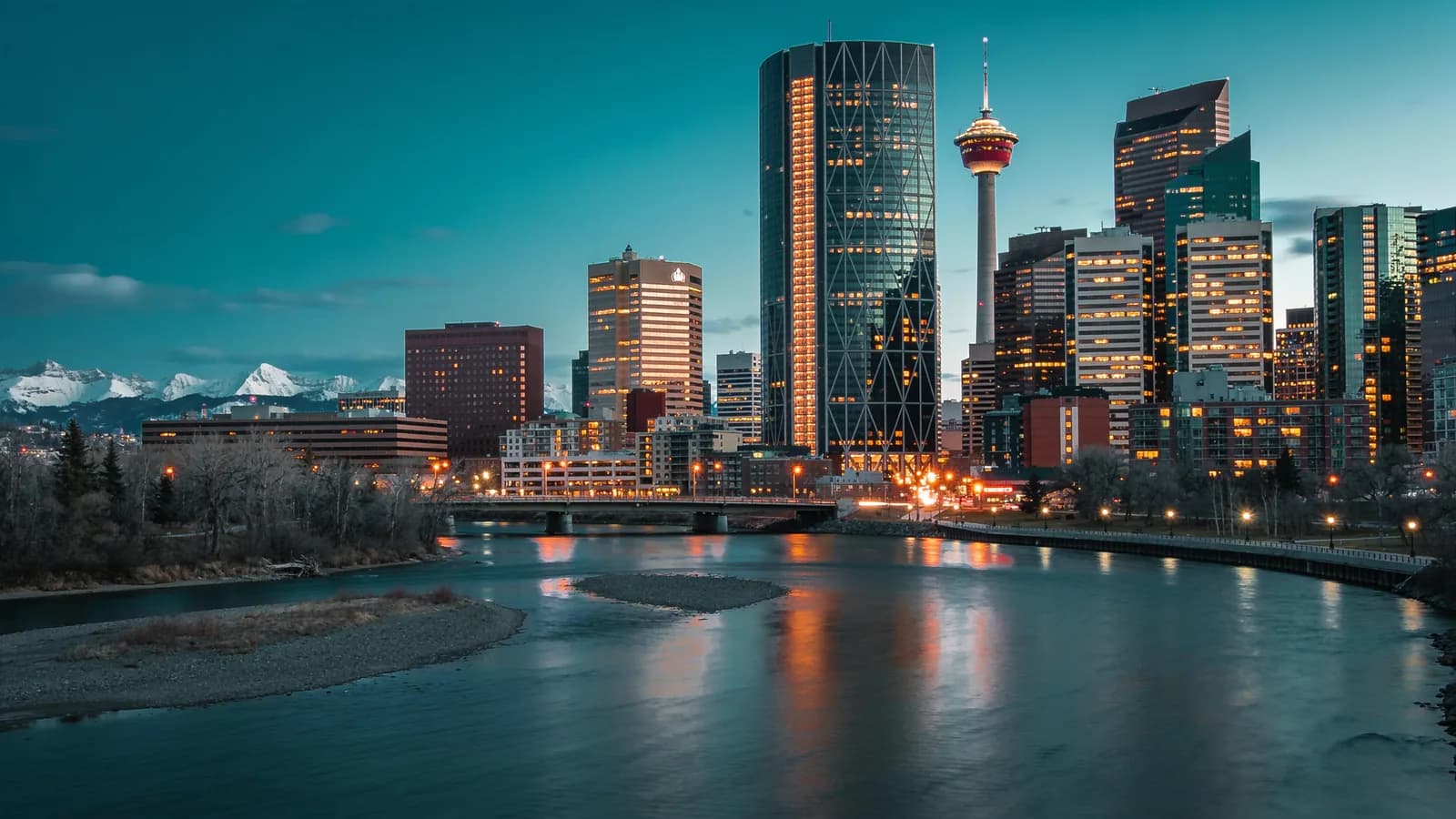Calgary skyline at dusk with the Calgary Tower, the Bow River and the Rockies on the horizon