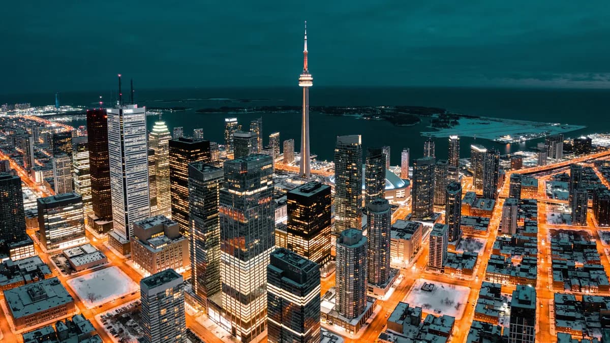 Aerial view of downtown Toronto at night with the CN Tower and the lake shore